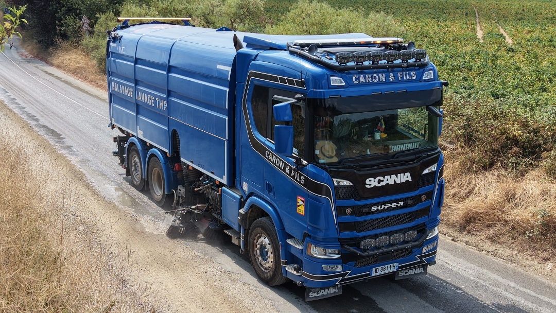 Balayeuse aspiratrice lourde Caron et Fils nettoyant la boue laissée par un tracteur sur une route départementale lors des récoltes agricoles