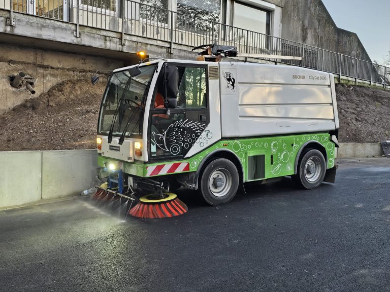 Balayeuse aspiratrice Caron et Fils nettoyant la boue à la sortie d'un chantier de terrassement dans les Hauts-de-France