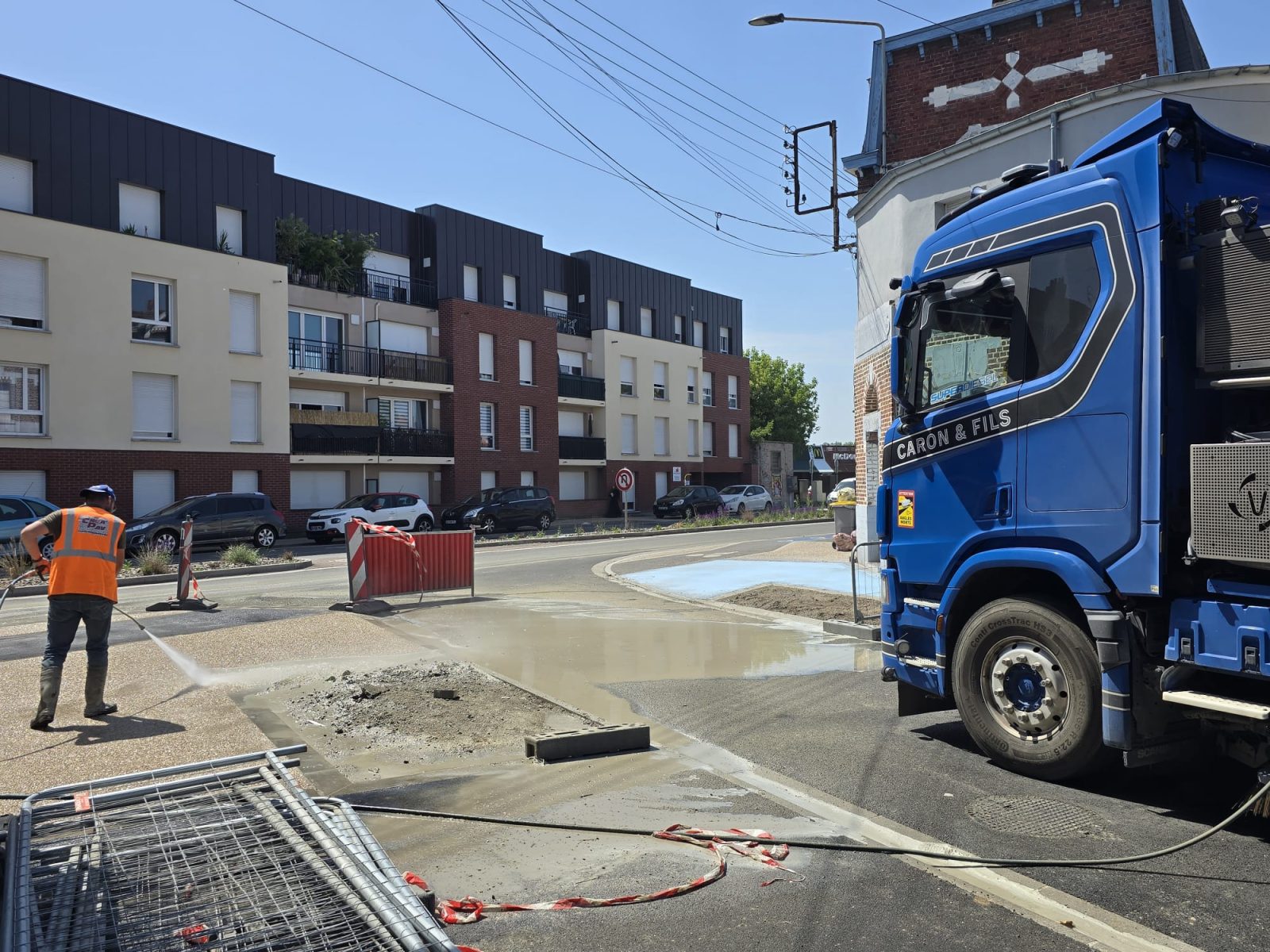 Balayeuse aspiratrice Caron et Fils en train de nettoyer l'asphalte d'une rue du centre-ville pour une commune des Hauts-de-France